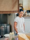 Junger Mann steht mit den Händen in den Taschen beim Kochen japanischer Ramen im Restaurant — Stockfoto