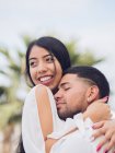 Young handsome man with closed eyes embracing attractive smiling woman — Stock Photo