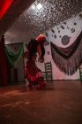 Танцовщица в костюме фламенко стоит в танцевальной позе на сцене — стоковое фото