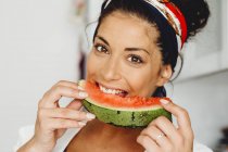Portrait of happy brunette woman eating delicious watermelon — Stock Photo