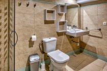 Інтер'єр ванної в сучасному простому стилі з душовою кабіною і туалетом — стокове фото