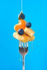 Склад солодкого десерту з чорницею, приправлений медом на синьому фоні — стокове фото