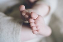 De dedos bonitos acima e adoráveis pernas de bebê gordas de recém-nascido em calças quentes — Fotografia de Stock