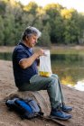 Side view of man preparing to eat fruit in the forest — Stock Photo