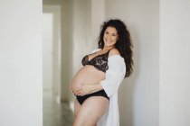 Mulher grávida feliz em roupa interior e roupão de banho em casa — Fotografia de Stock