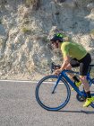 Close-up de homem saudável andar de bicicleta na estrada da montanha em dia ensolarado — Fotografia de Stock