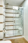 Інтер'єр ванної в мінімалістичному сучасному стилі, прикрашеному білою плиткою з душовою кабіною — стокове фото