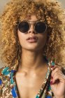 Portrait de femme rétro séduisante avec des cheveux bouclés dans des lunettes de soleil élégantes — Photo de stock