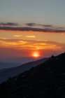 Pittoresca vista di maestoso tramonto luminoso sopra scure scogliere piccanti — Foto stock
