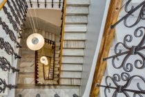 Stylish stairs decorated with marble and wrought iron railing — Stock Photo
