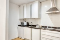 Інтер'єр стильної білої порожньої кухні з сучасною технікою і меблями — стокове фото