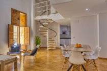 Interior of simple stylish dining room and stairs in modern duplex flat in daylight — Stock Photo