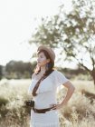 Retrato de mujer en ropa blanca y sombrero de pie al aire libre a la luz del día con cámara — Stock Photo
