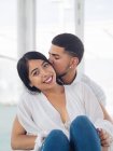 Young handsome man with closed eyes hugging attractive smiling woman — Stock Photo