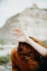 Femme anonyme tenant la main au-dessus de la tête sur fond de désert sauvage paysage — Photo de stock