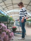 Жінка вибирає рослини для саду на квітковому ринку — стокове фото