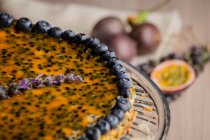Appetizing fragrant passion fruit pie with blueberry topping decorated with bunch of lavender — Stock Photo