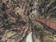 Escursionista che ammira la maestosa vista delle Alpi passeggiando in passerella nelle Dolomiti — Foto stock