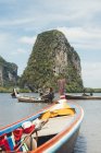 Wooden boats floating on peaceful water of lagoon with green rock on background, Thailand — Stock Photo