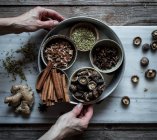 Vista dall'alto di mani irriconoscibili con spezie secche miste e funghi composti su tavola di marmo per cucinare la zuppa di Pho — Foto stock