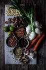 Сверху доски со свежими овощами и специями с сухой лапшой для приготовления традиционного супа Фо — стоковое фото