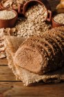 Свежеиспеченный нарезанный ржаной хлеб на салфетке на деревянном столе — стоковое фото