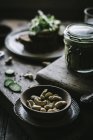 Small wooden bowl of raw cashew nuts for preparing green vegan pate on wooden board — Stock Photo