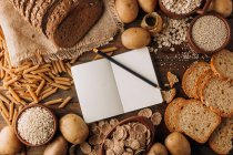 Cibo integrale notebook vuoto e pane di segale appena sfornato sulla tavola — Foto stock