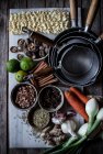 Von oben von Bord mit frischem Gemüse und Gewürzen mit trockenen Nudeln zum Kochen traditioneller Pho-Suppe — Stockfoto