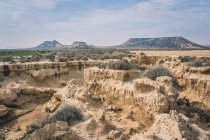 Erstaunliche Wüstenlandschaft mit zerklüfteten Felsen, trockener Vegetation und Hügeln — Stockfoto