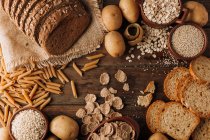 Wholegrain food and freshly baked rye bread on table — Stock Photo
