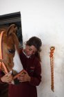 Adolescente embrasser avec petit poney dans chapeau mignon sur les oreilles debout à l'intérieur de l'écurie — Photo de stock