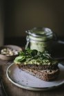 Torradas com pate de caju verde, ervas e fatias de pepino com jarra em tábua de madeira — Fotografia de Stock