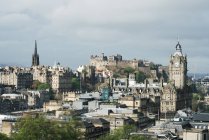 Vista panorámica del casco antiguo con edificios góticos contra las nubes a la luz del sol, Escocia - foto de stock