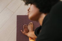 Nahaufnahme einer Frau, die zu Hause auf einer Matte Yoga macht — Stockfoto