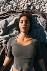 Portrait de jeune femme attrayante afro-américaine allongée sur la plage de galets — Photo de stock