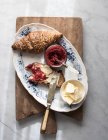 Croissant croustillant et pain grillé au beurre et confiture de fraises servi sur planche de bois — Photo de stock