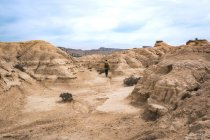 Чоловік ходить по дивовижному ландшафту пустельних пагорбів на тлі блакитного неба — стокове фото