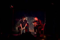 Hispanische Männer mit Percussion und Akustikgitarre während eines Flamenco-Auftritts auf der dunklen Bühne — Stockfoto