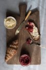 Хрусткий круасан і тости з маслом і полуничним мармеладом, які подаються на дерев'яній дошці — стокове фото
