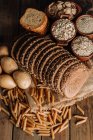 Pan de centeno recién horneado en rodajas en servilleta sobre mesa de madera - foto de stock