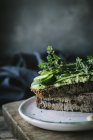 Toasts mit grüner Cashewpastete, Kräutern und Gurkenscheiben auf Holzbrett — Stockfoto