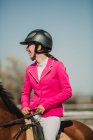 Close-up view of teenage jockey on horse riding on racetrack on a sunny day — Stock Photo