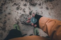 Nahaufnahme der Hand in schwarzem fingerlosen Handschuh mit Kompass auf Wüstenplatz — Stockfoto