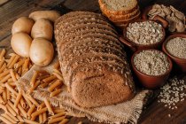 Свіжоспечений нарізаний житній хліб на серветці на дерев'яному столі — стокове фото