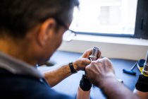 Engenheiro protético revisando a prótese de um paciente e melhorando o material em sua oficina — Fotografia de Stock