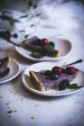 Шматок смачного торта з літніми ягодами на тарілці на білому столі — стокове фото