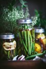 Composition of potted plant, lemons and glass jar with raw green beans in wooden box — Stock Photo