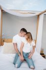 Schöne junge Frau und Mann schauen einander im Schlafzimmer an — Stockfoto