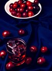 Boisson rouge près des fruits frais sur tissu bleu — Photo de stock
